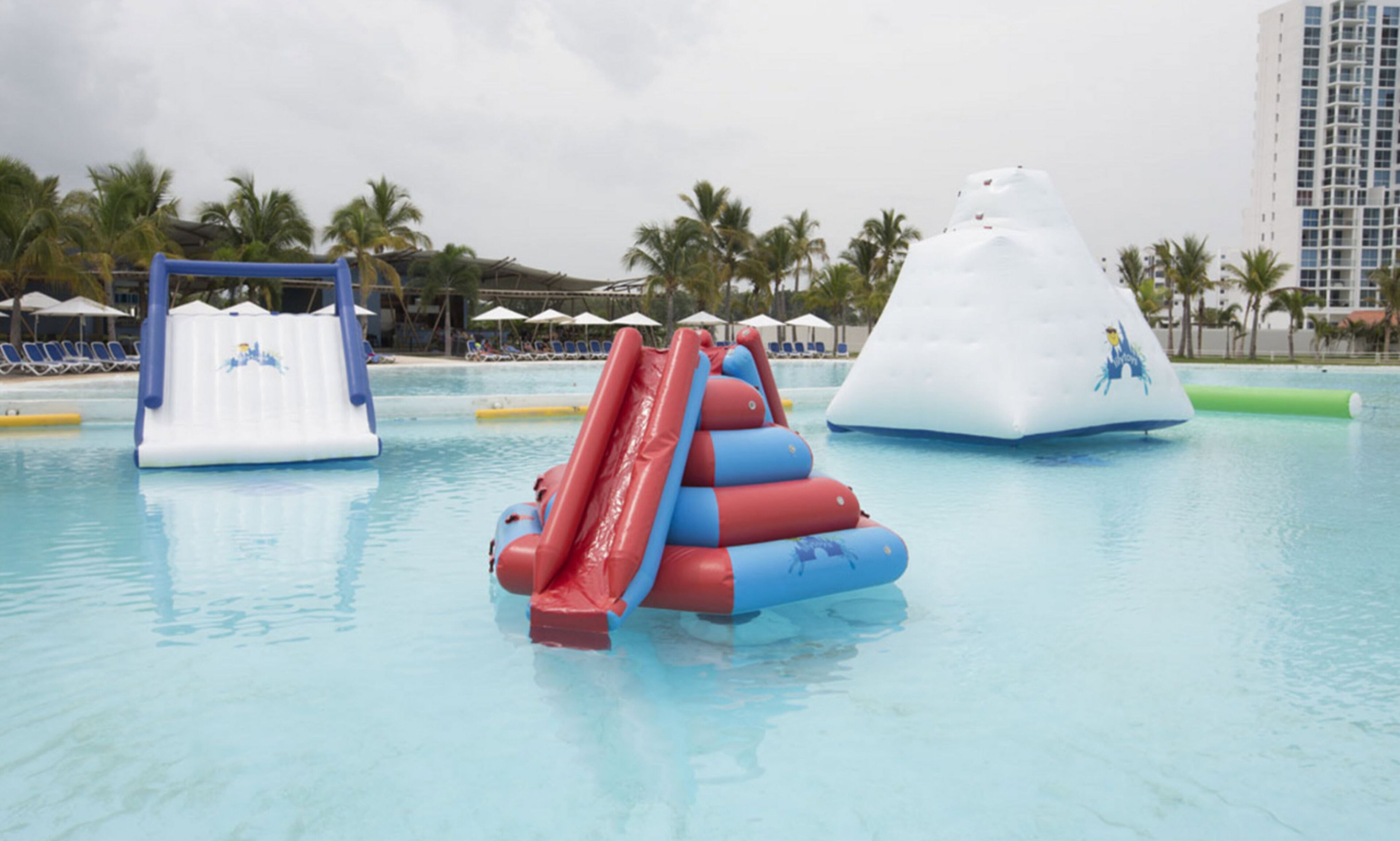 Un espace piscine avec des toboggans gonflables et un toboggan aquatique.