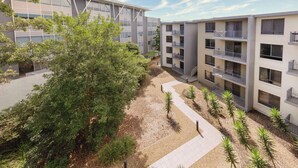 Un edificio moderno de varios pisos con balcones y un patio.