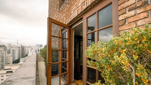 Un edificio con fachada de ladrillo, grandes ventanales y vistas a un paisaje urbano.