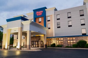 Hotel Hampton Inn & Suites by Hilton con fachada moderna, entrada despejada y estacionamiento.