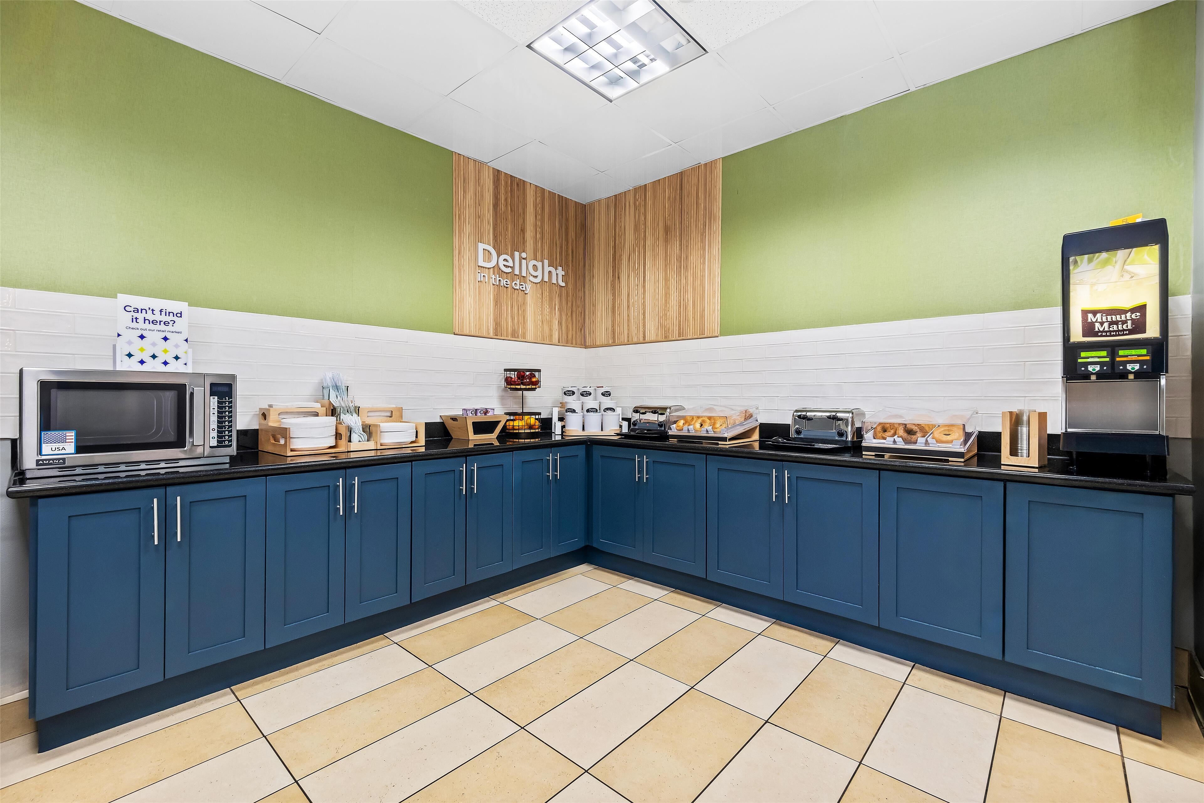 Una cucina moderna con mobili blu, un forno a microonde e una macchina per il caffè.