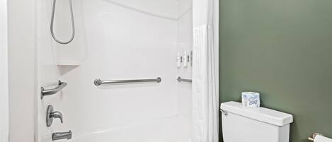 Une salle de bain avec une baignoire, des toilettes et un rideau de douche.