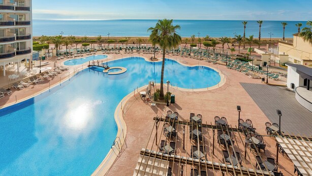 A resort with a large pool, lounge chairs, and a view of the ocean. - Hotel & Spa Peñíscola Plaza Suites (Peniscola)
