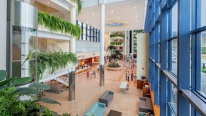 A spacious atrium with multiple levels, indoor plants, and seating areas. - Hotel & Spa Peñíscola Plaza Suites (Peniscola)
