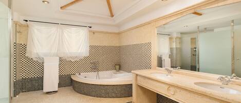 A modern bathroom with a freestanding bathtub, two sinks, a large mirror, and a ceiling fan.