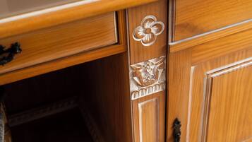 A wooden cabinet with intricate floral carvings and a brass handle.