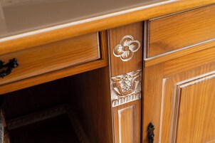 A wooden cabinet with intricate floral carvings and a brass handle.