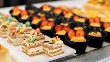 Eine Auswahl an Desserts auf einem Buffet, darunter Schichttorten und Obsttorten.