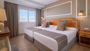 A hotel room with two beds, a large window, a wooden headboard, and a nightstand. - Hotel & Spa Peñíscola Plaza Suites (Peniscola)
