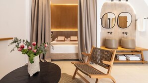 A modern hotel room with a bed, a wooden chair, a vanity with mirrors, and a vase of flowers. - Albatros Spa & Resort Hotel (Hersonissos)