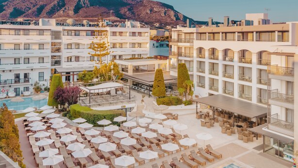 A hotel with a pool area, outdoor seating, and a view of the surrounding buildings. - Albatros Spa & Resort Hotel (Hersonissos)