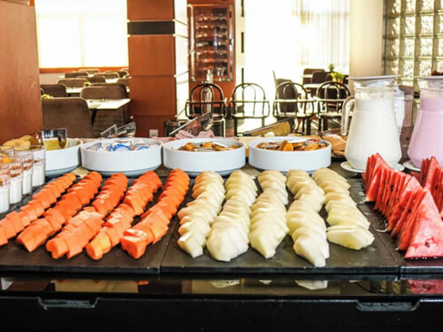 A buffet with various food items including sliced fruits, vegetables, and dairy products.
