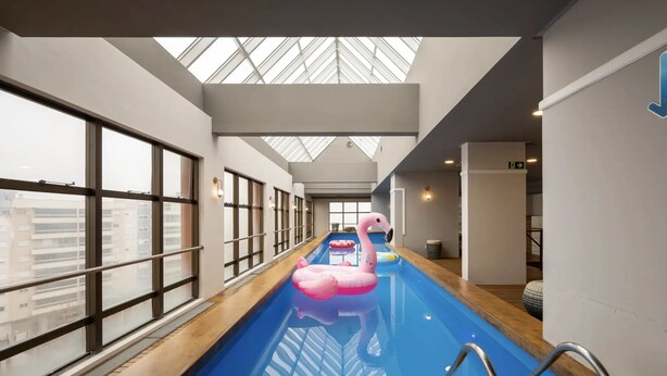 An indoor swimming pool with a pink flamingo float and a swan float. - Intercity Caxias do Sul (Caxias do Sul)
