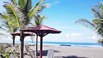 On the beach, black sand, free beach cabanas, sun loungers