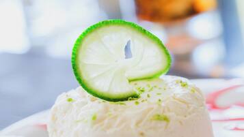 A dessert with a lime slice on top, served on a plate with a floral pattern.