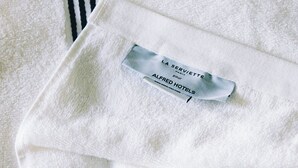 Ein weißes Handtuch mit einem Etikett, das angibt, es stammt von La Serviette Paris, Alfred Hotels.