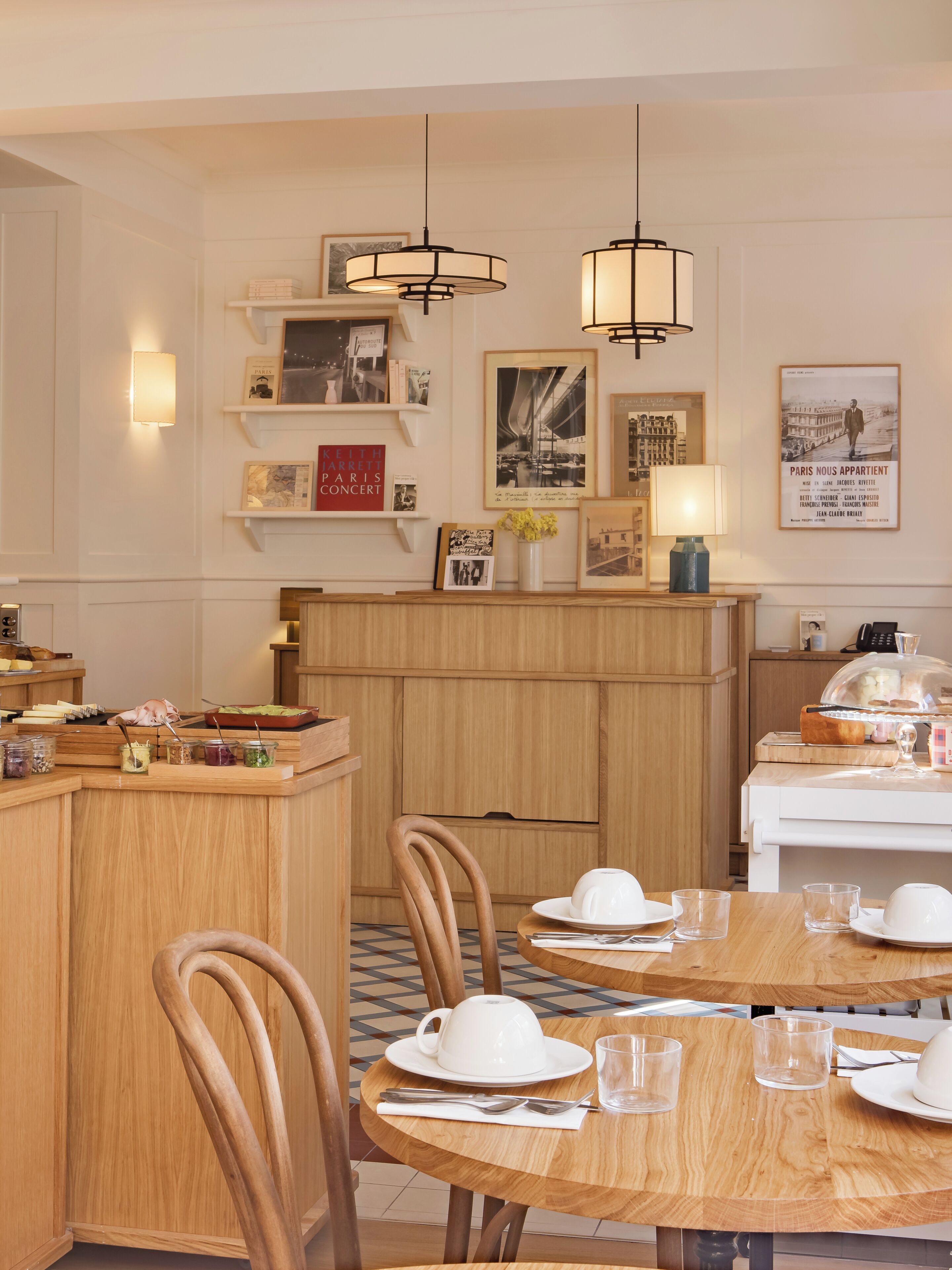 Zona pranzo con tavoli e sedie in legno e un banco buffet con diverse pietanze.