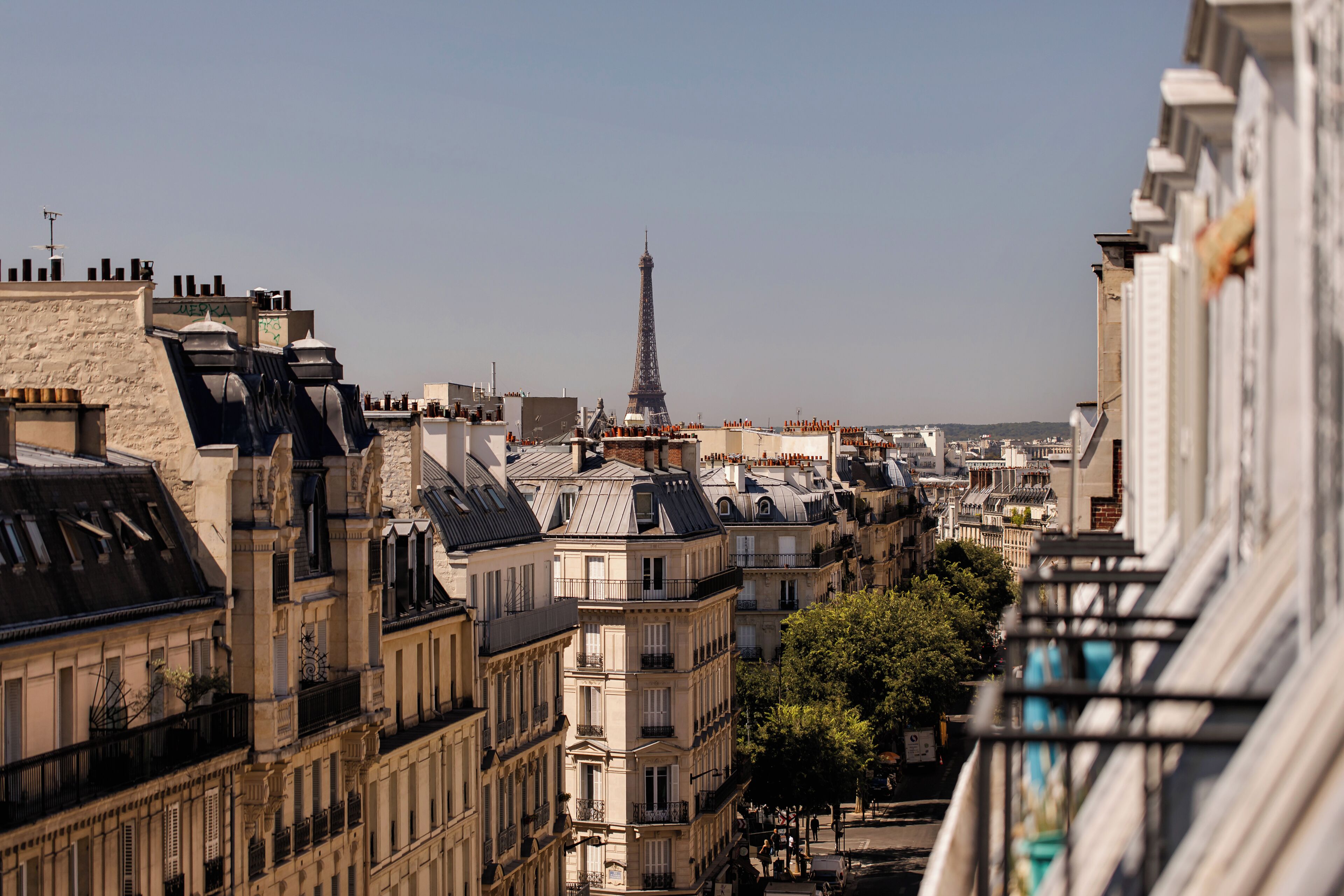 A cityscape with a prominent tower in the distance, surrounded by densely packed buildings with varied architectural styles.