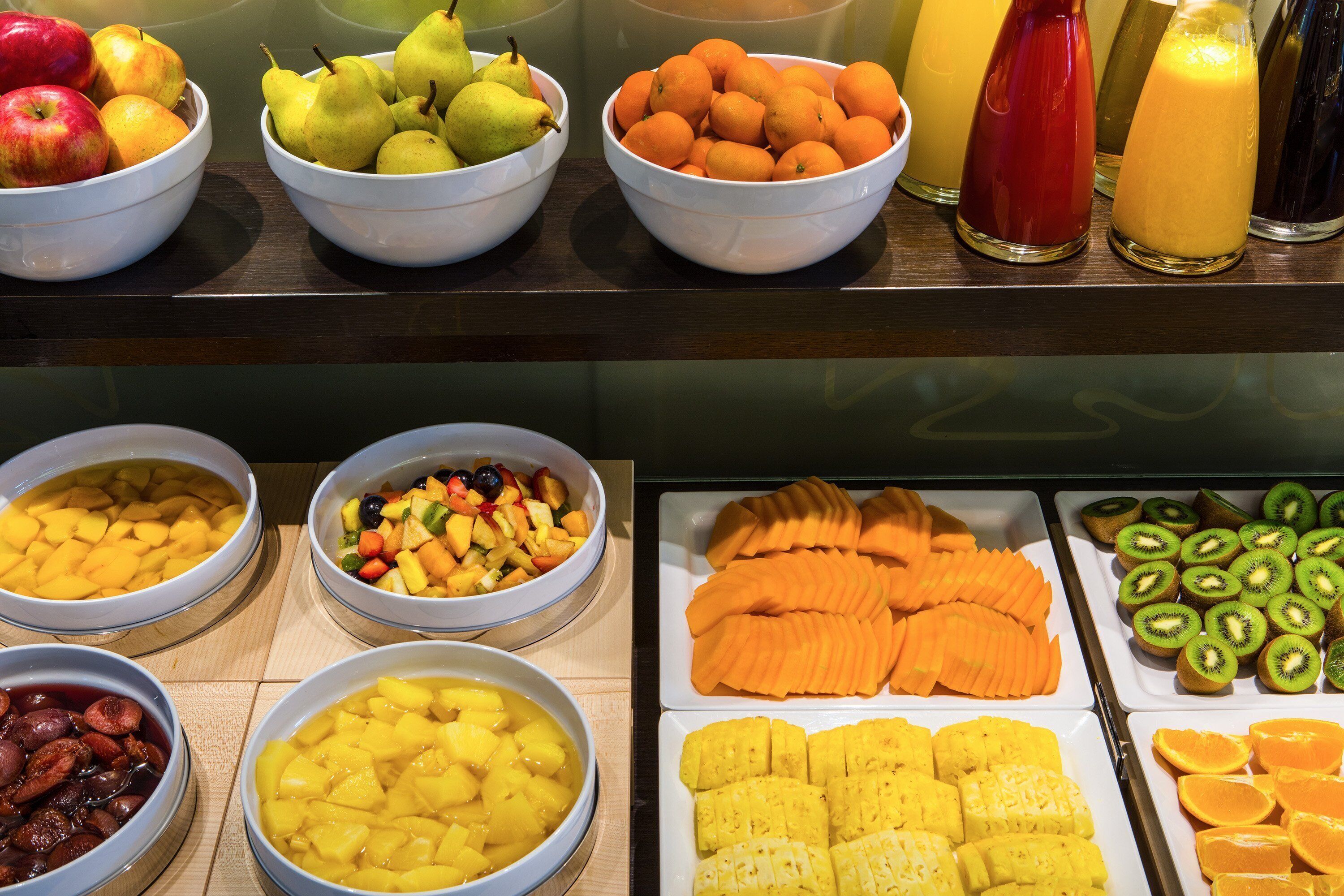 Une variété de fruits et de boissons disposés sur une table de buffet.