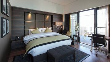 A modern hotel room with a large bed, a desk, and a chair.