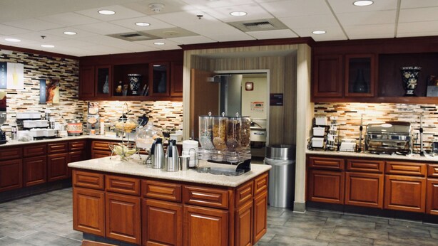 A spacious kitchen with wooden cabinets, a central island, and various appliances.