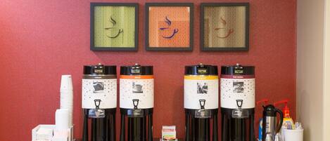 Un espace dédié au café, équipé de quatre machines à café, de gobelets jetables et d’un moulin à café.