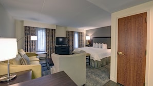 A hotel room with a bed, a desk with a lamp, a television, and a chair. - Hampton Inn & Suites Rockville Centre (Rockville Centre)