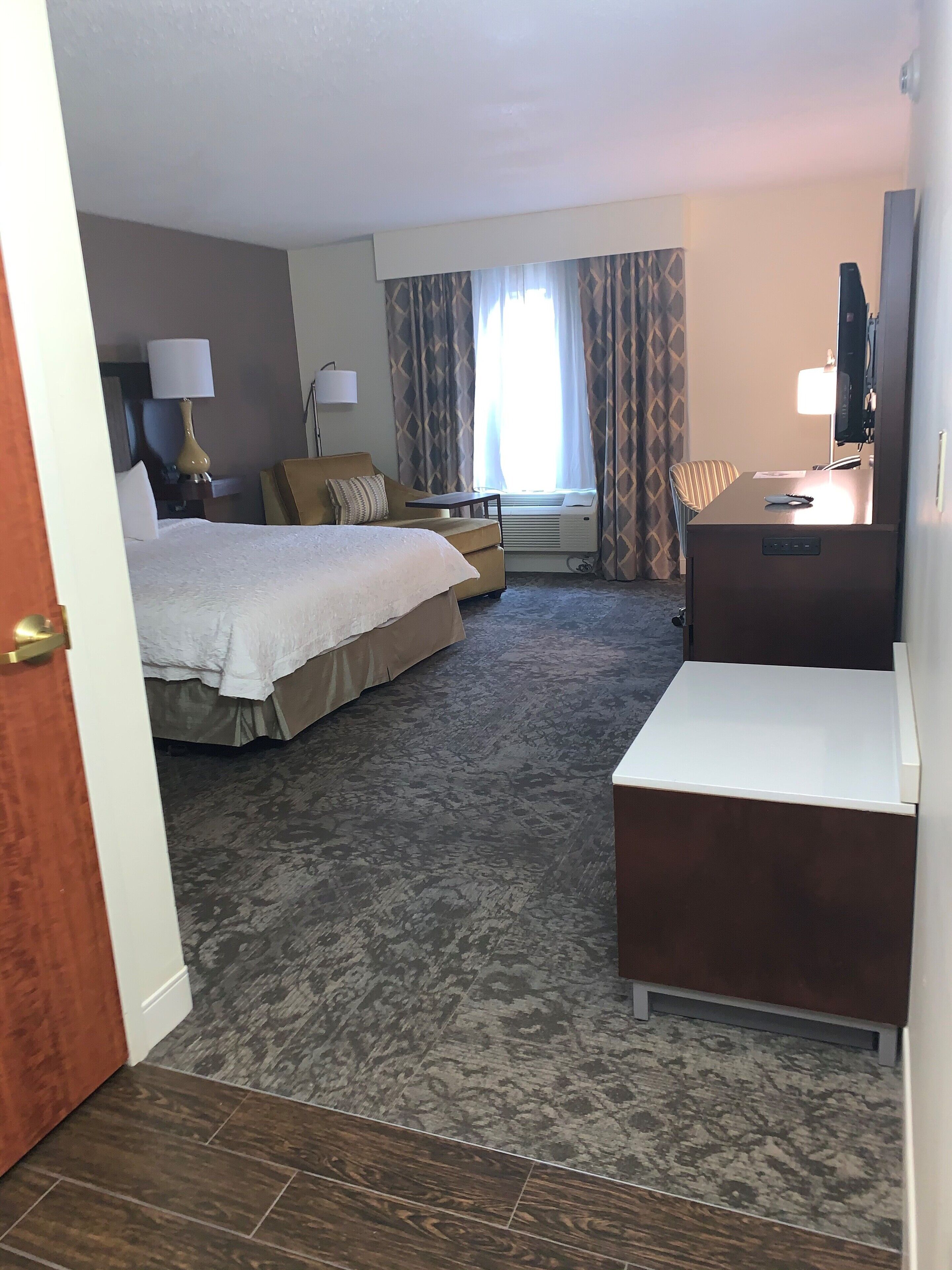 Une chambre d’hôtel équipée d’un lit, d’un bureau, d’une chaise et d’un téléviseur.