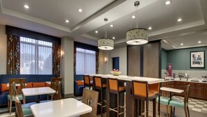 A modern restaurant with booths and high tables, wooden flooring, and pendant lighting. - Hampton Inn Shreveport Airport (Shreveport)