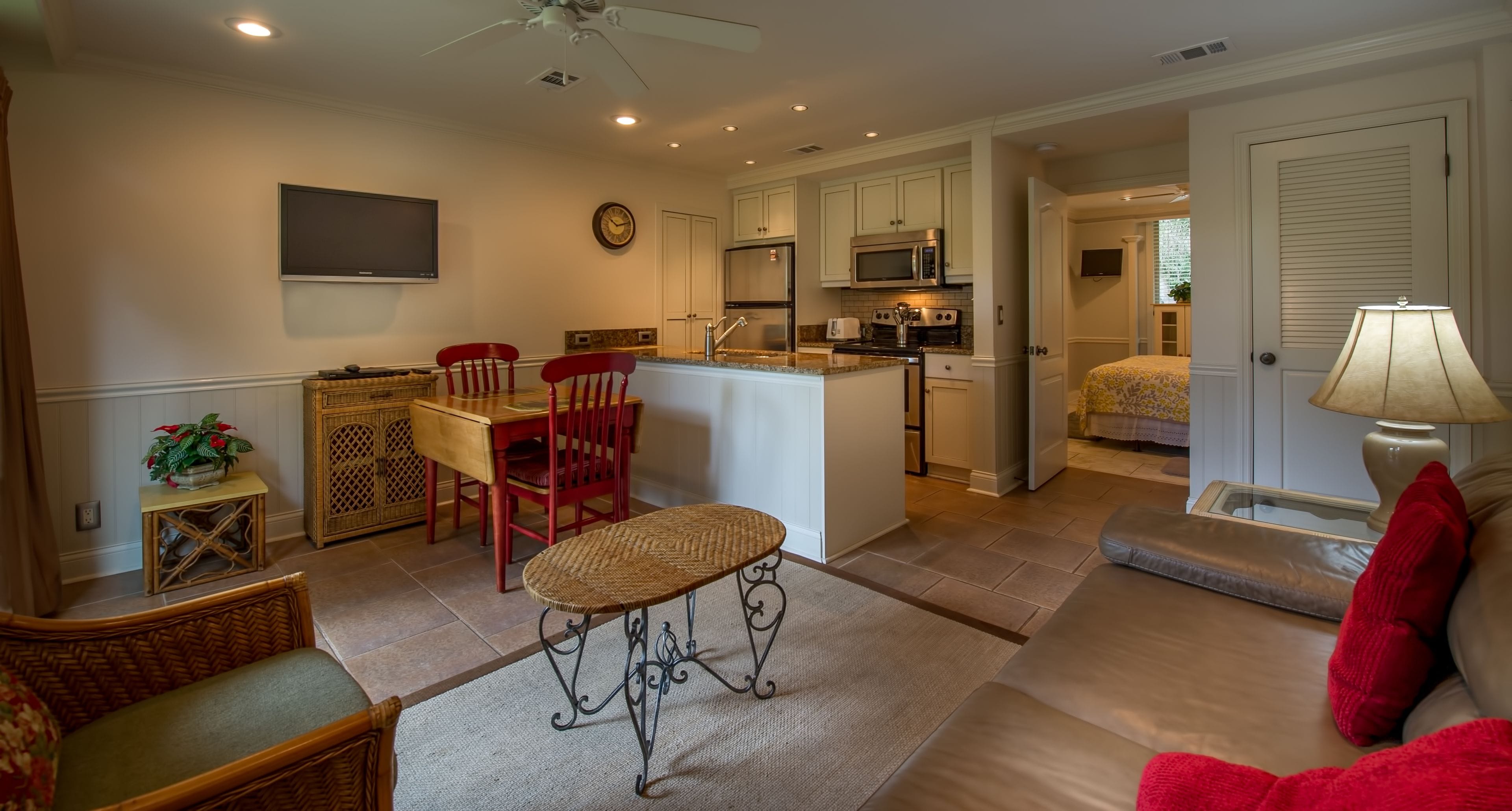 Un espace de vie compact comprenant une cuisine, un coin repas et une chambre.