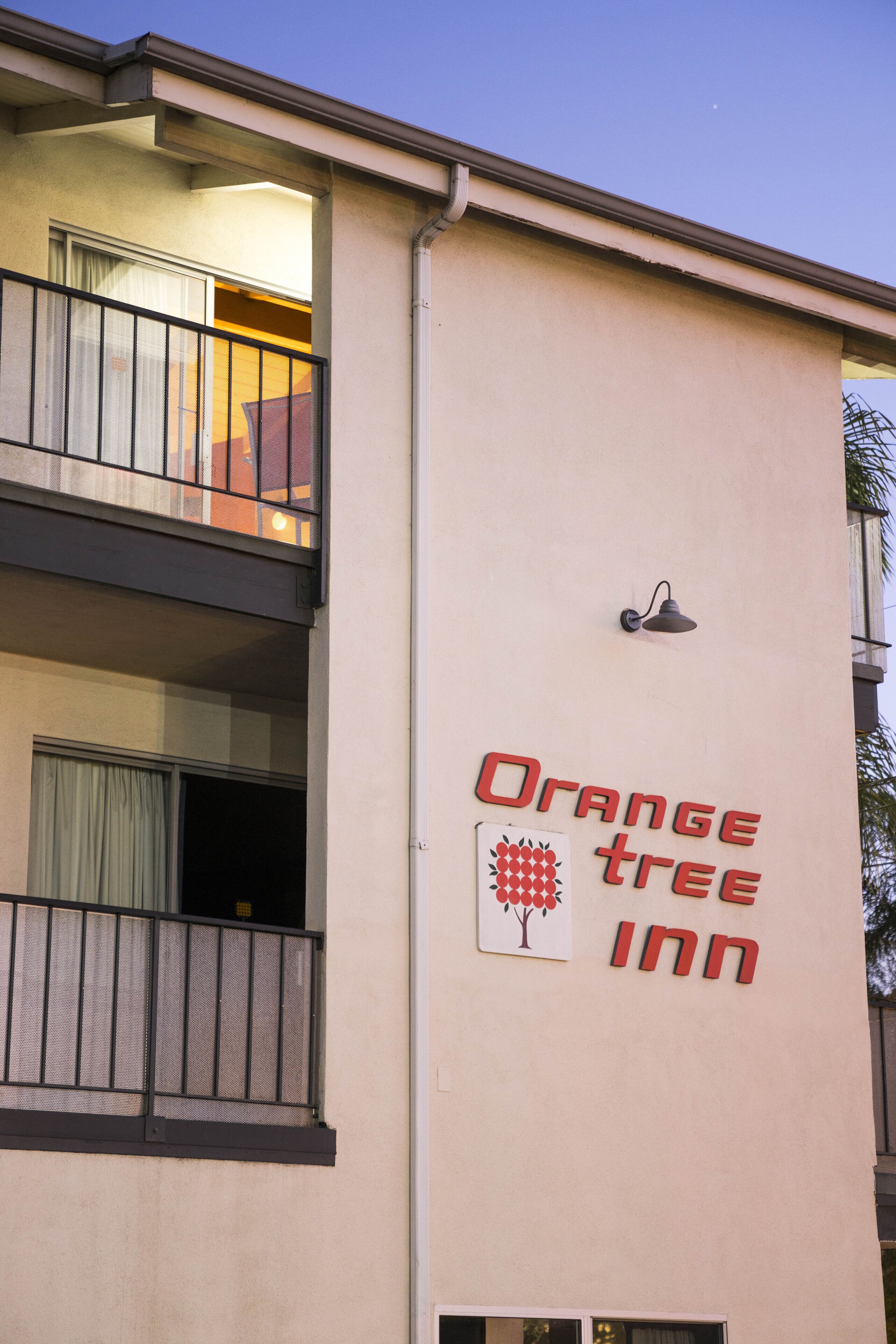 A building with a sign reading "Orange Tree Inn" and a tree logo.
