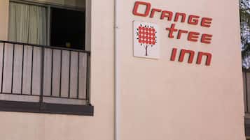 A building with a sign reading "Orange Tree Inn" and a tree logo.