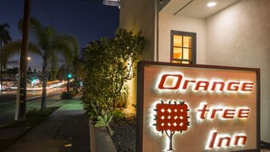Une enseigne pour l’auberge « Orange Tree », avec une représentation graphique d’un arbre.