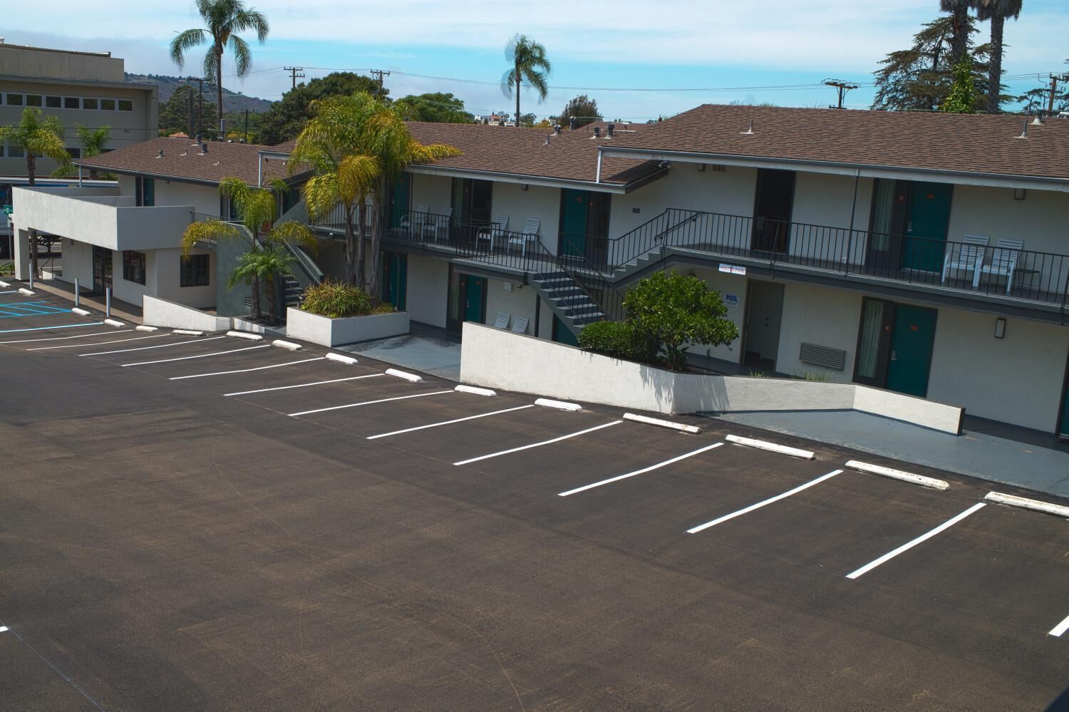 Un motel doté d’un parking, d’une piscine et d’un escalier menant au deuxième étage.
