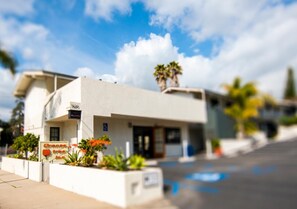 A modern building with a sign for 'Orange' and a parking area. - Orange Tree Inn (Santa Barbara)