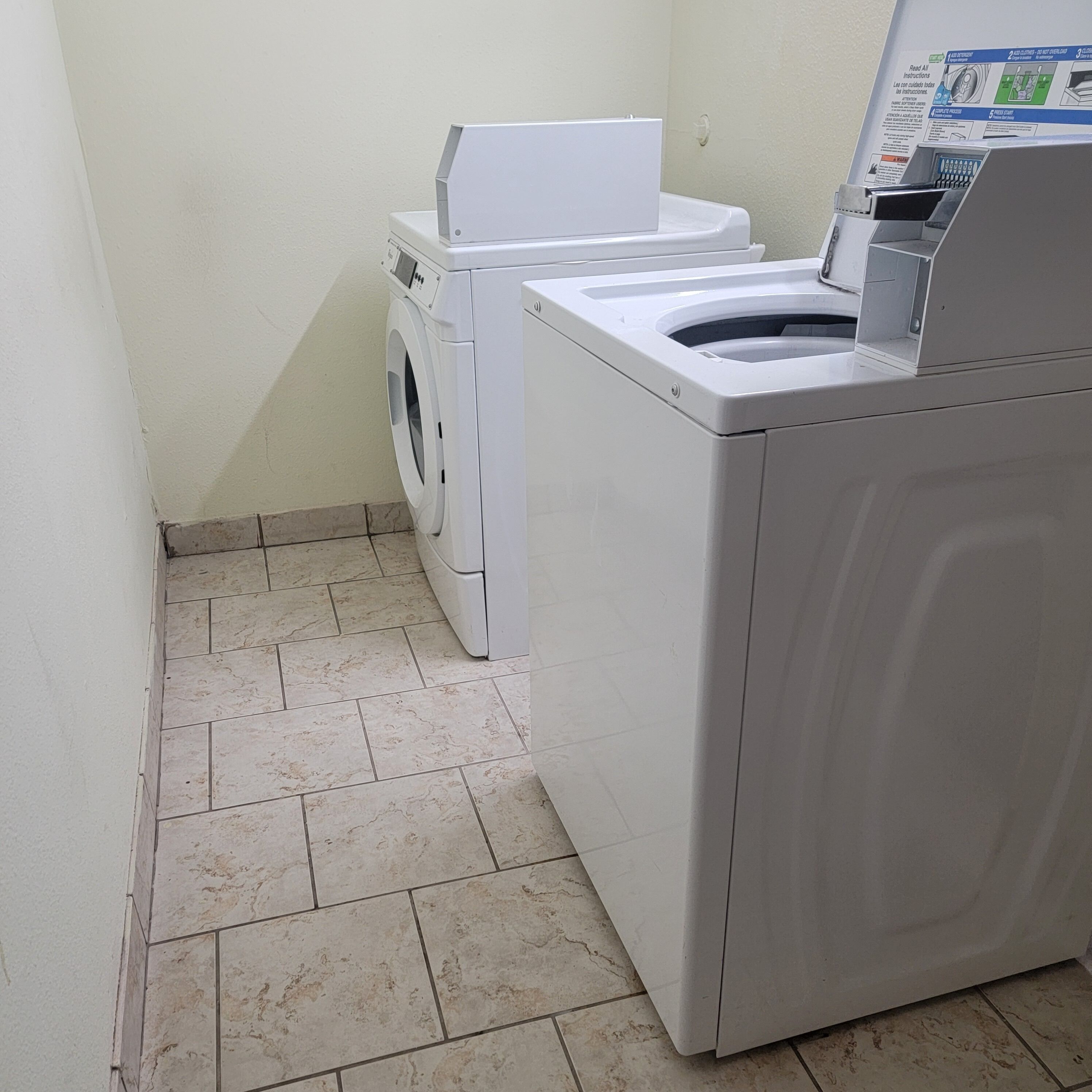 A laundry area with a front-loading washing machine and a stacked dryer.