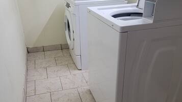 A laundry area with a front-loading washing machine and a stacked dryer.