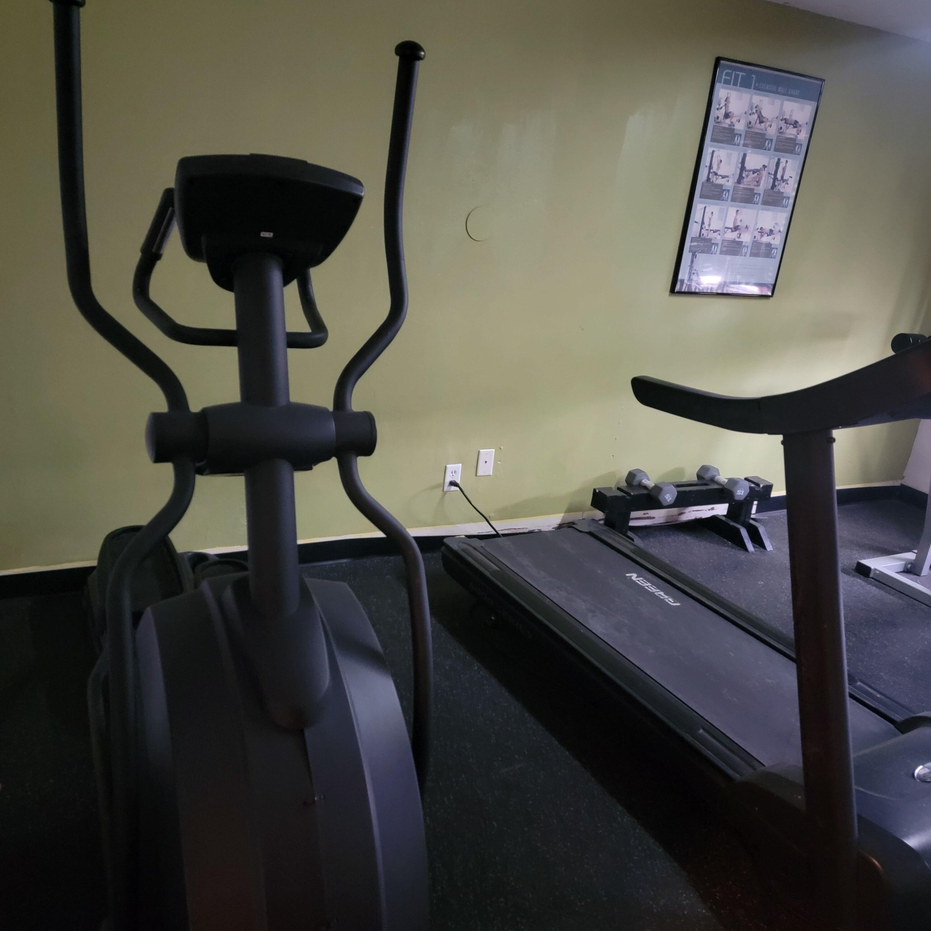 A gym with exercise equipment including a stationary bike and a treadmill.