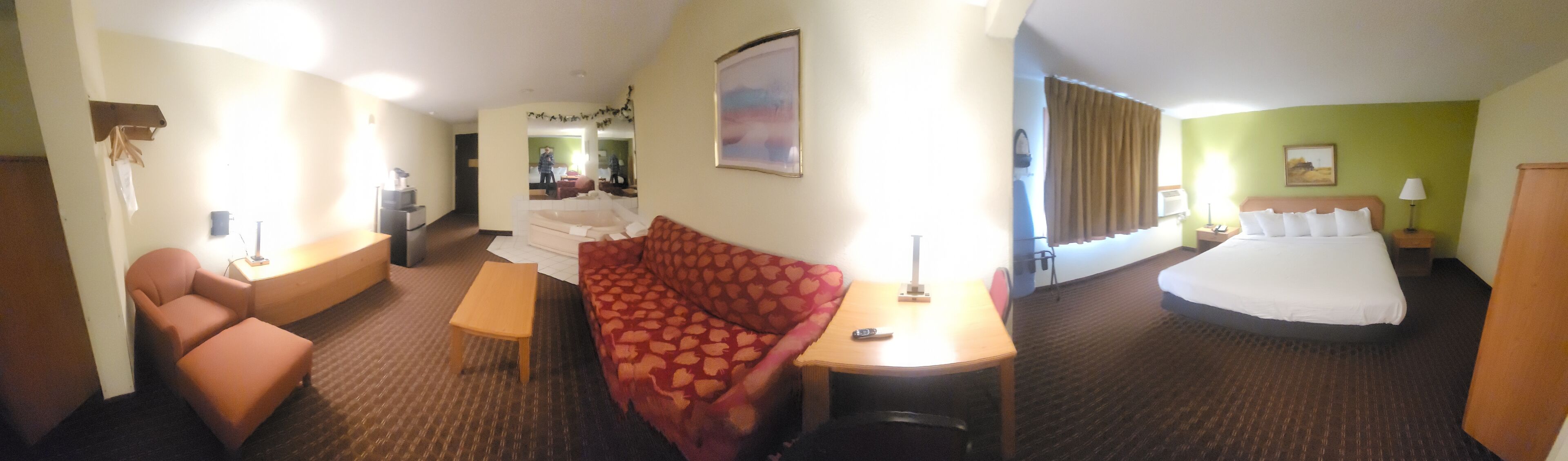 Une chambre d’hôtel comprenant un lit, un bureau, une chaise, un canapé et une petite table.