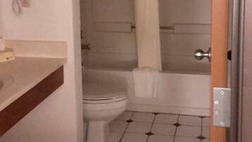 Ein Badezimmer mit Toilette, Waschbecken und Duschbereich.