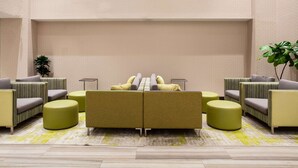 A modern lounge area with a sofa set, ottomans, and a small table. - Wingate by Wyndham - Orlando International Airport (Orlando)