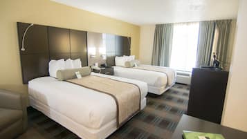 A hotel room with two beds, a desk, a chair, and a flat-screen TV.