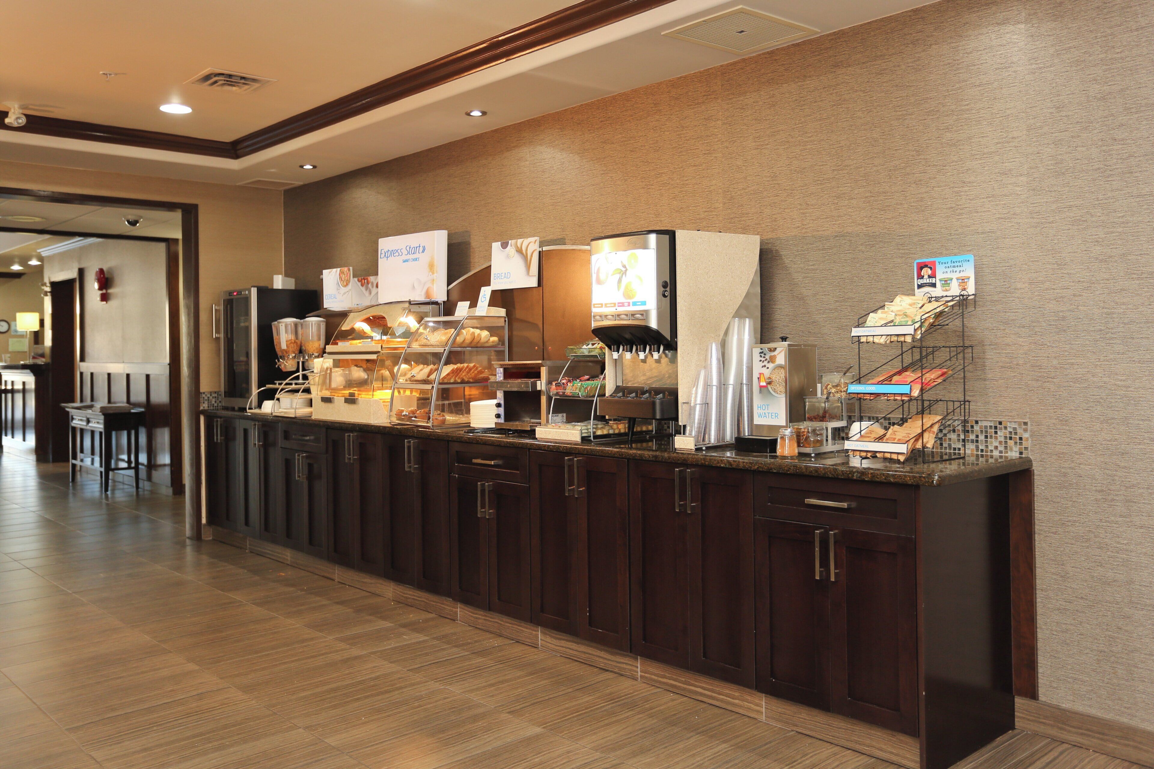 A self-service breakfast bar with various food options and a coffee machine.