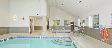 An indoor swimming pool with clear lane markings and a lifebuoy.