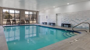 An indoor swimming pool with clear water, a tiled wall, and a bench near the pool. - Hampton Inn & Suites by Hilton Windsor (Windsor)