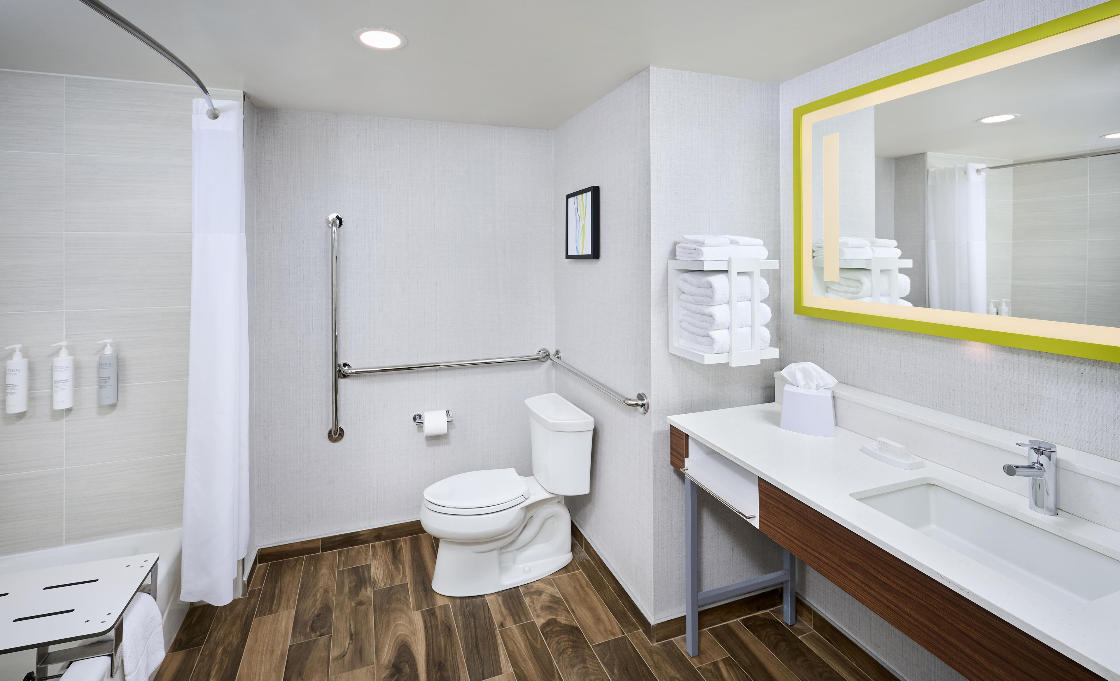 A modern bathroom with a shower, toilet, and sink.
