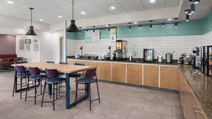 Un área de cocina moderna con encimera de madera, taburetes de bar y un salpicadero de azulejos.
