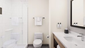 A modern bathroom with a shower, toilet, and sink.
