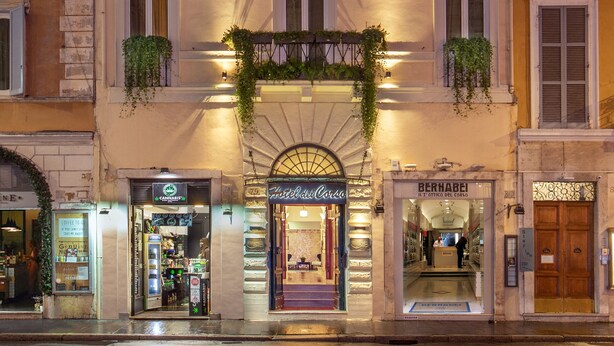 La façade d’un hôtel ornée de nombreux balcons, un café et une boutique.