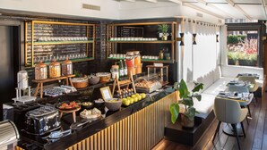 Un buffet pour le petit-déjeuner proposant divers aliments et une machine à café.